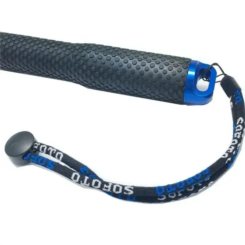 Svart grepp med prickigt mönster och blå metallände med handledsrem märkt Soft Otto