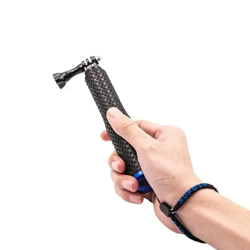 Hand håller svart greppvänligt kamerahandtag med blått fäste och handrem mot vit bakgrund