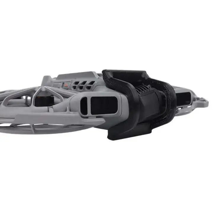 Detaljerat DJI Neo 2 linsskydd, svävande över en sjö, förbättrar drönarens lins och skyddar mot repor.